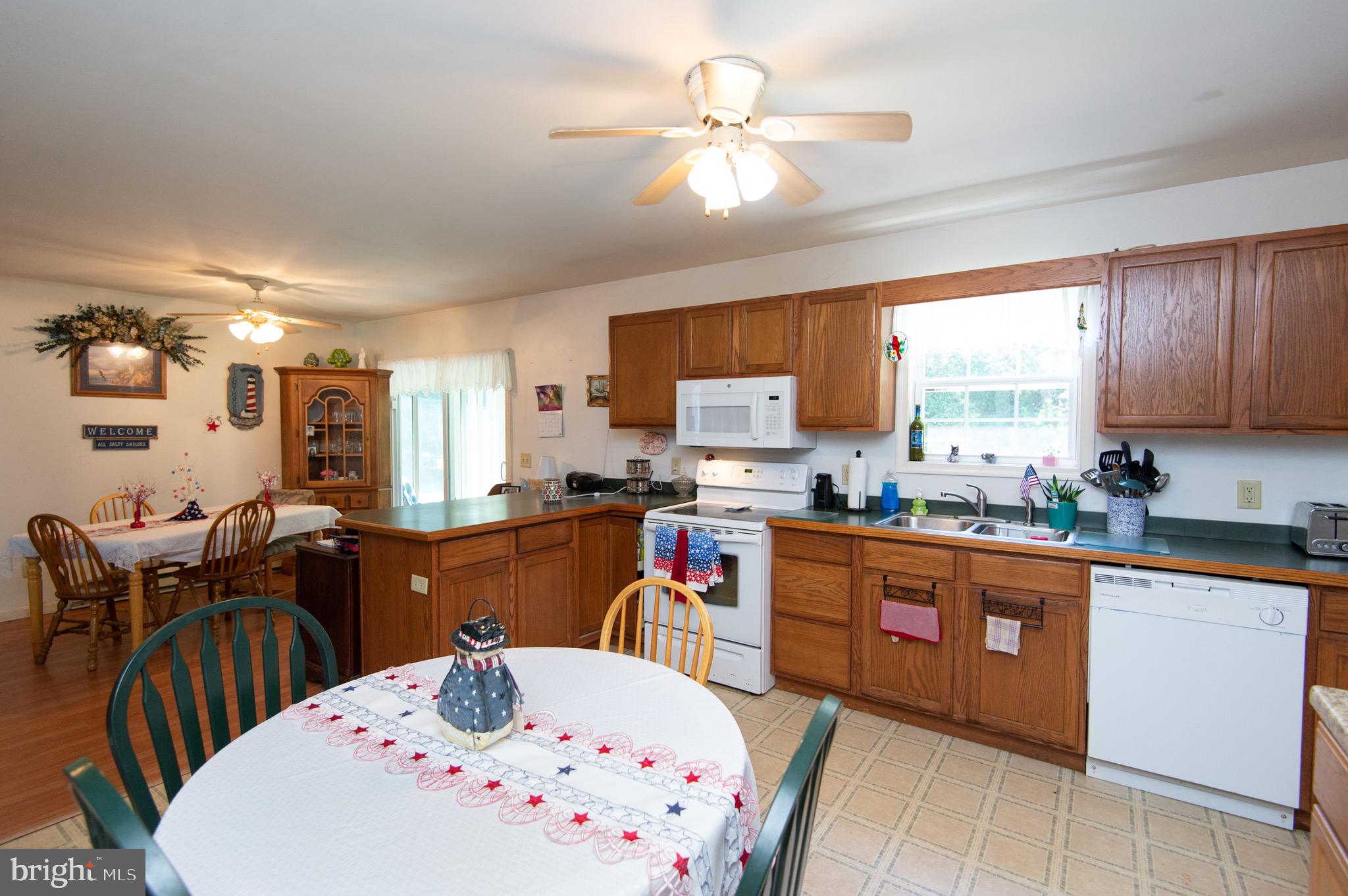 5834 Bell Creek Road Preston, MD 21655 - Photo 19 of 44 a kitchen with stainless steel appliances granite countertop a stove a sink a dining table and chairs