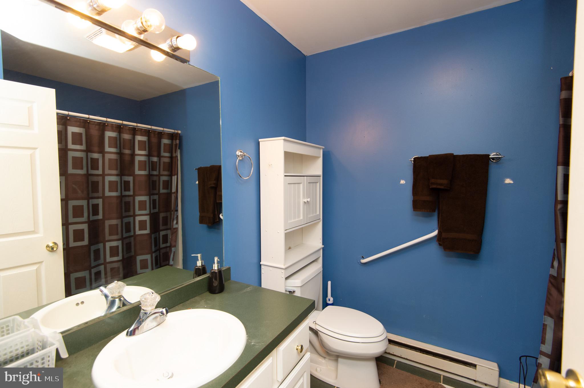 5834 Bell Creek Road Preston, MD 21655 - Photo 30 of 44 a bathroom with a granite countertop toilet sink and mirror