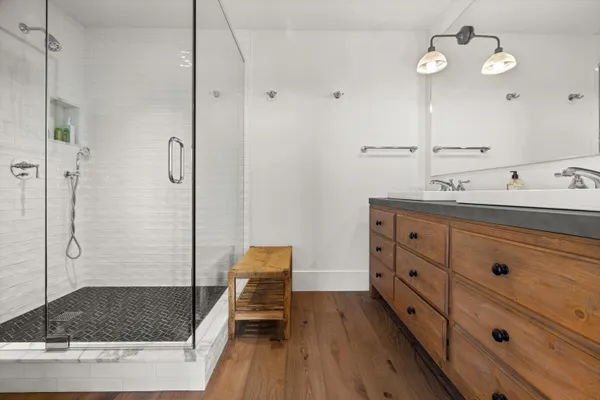 a bathroom with a shower a sink and a mirror