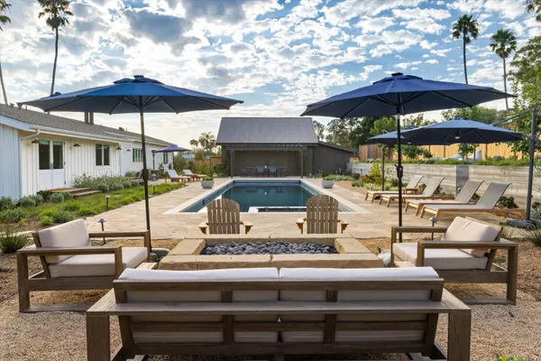 a view of a patio with table and chairs under an umbrella