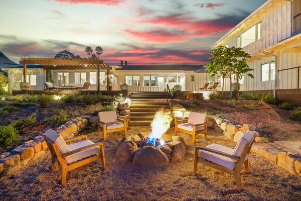 a view of a chairs and table in the backyard