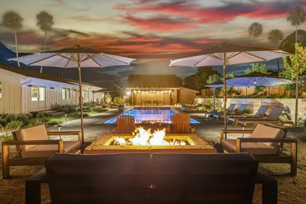 a view of a patio with couches chairs under an umbrella