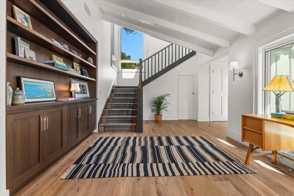 a view of a living room with wooden floor and staircase