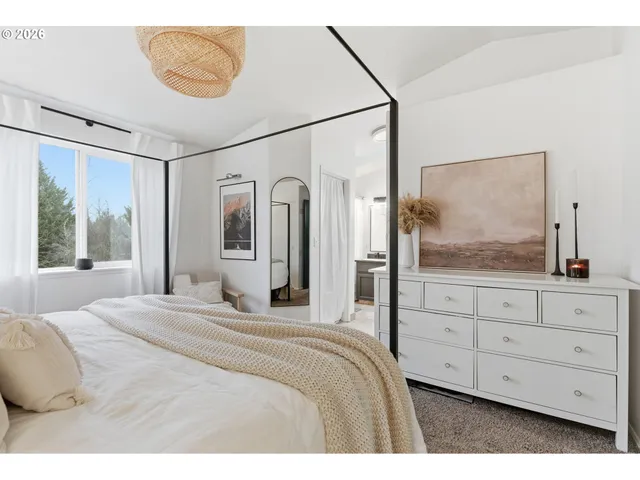 a bedroom with a large bed and a chandelier