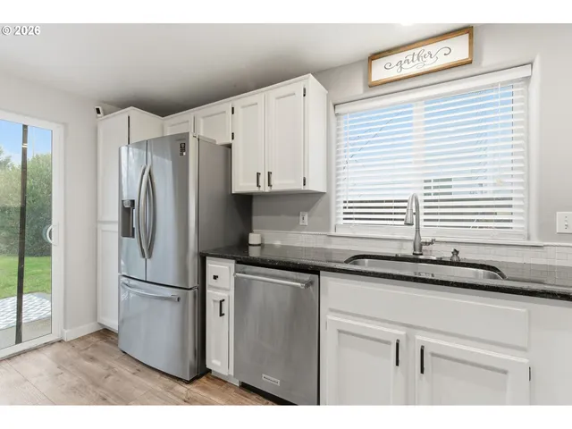 a kitchen with granite countertop a sink and a refrigerator