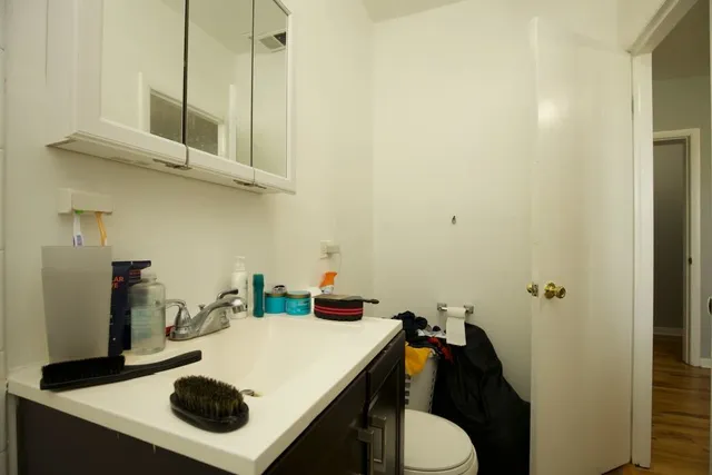 a bathroom with a sink toilet and a mirror