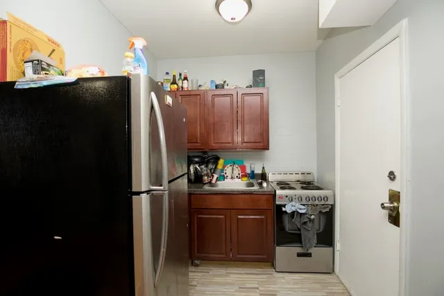 a view of a kitchen with fridge and workspace