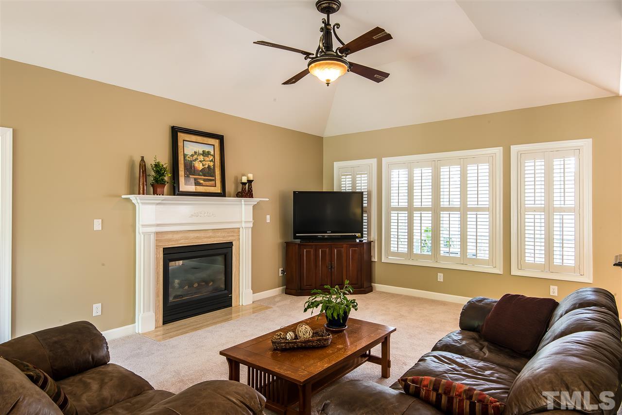 8200 Eden Close Court Raleigh, NC 27613 - Photo 7 of 15 a living room with furniture a flat screen tv and a fireplace