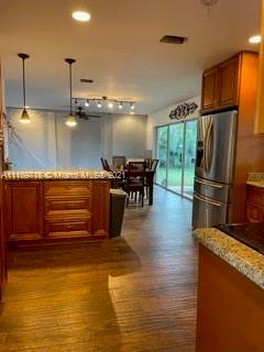 49 Southwest 9th Avenue Boca Raton, FL 33486 - Photo 3 of 8 a kitchen with stainless steel appliances granite countertop a refrigerator a stove and a wooden floors