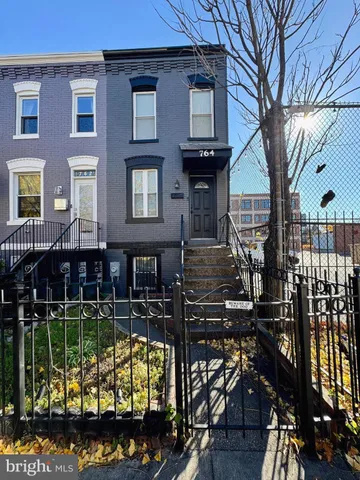 a view of a brick house with wooden fence