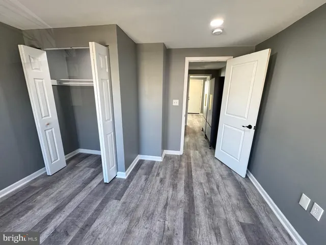an empty room with wooden floor and entrance