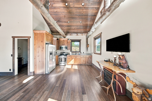 1063 West Kolob Ranch Drive Springdale, UT 84767 - Photo 43 of 61 Vaulted wood-plank ceilings with exposed timber beams, wood-finish flooring, and a kitchen featuring wood cabinetry, stainless steel appliances, and a window