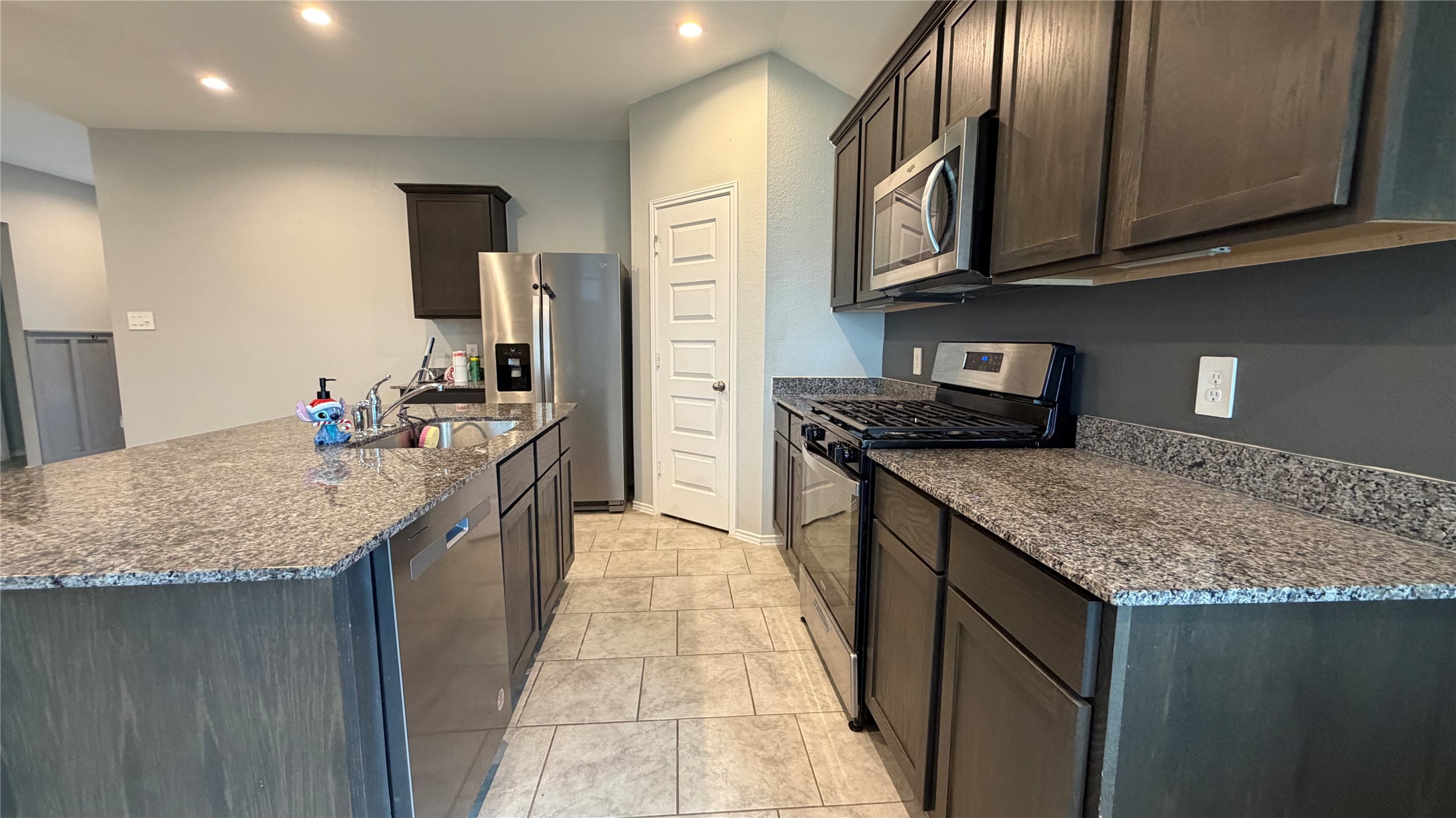 7518 Cynomys Court Rosharon, TX 77583 - Photo 9 of 21 a kitchen with stainless steel appliances granite countertop a sink stove and refrigerator