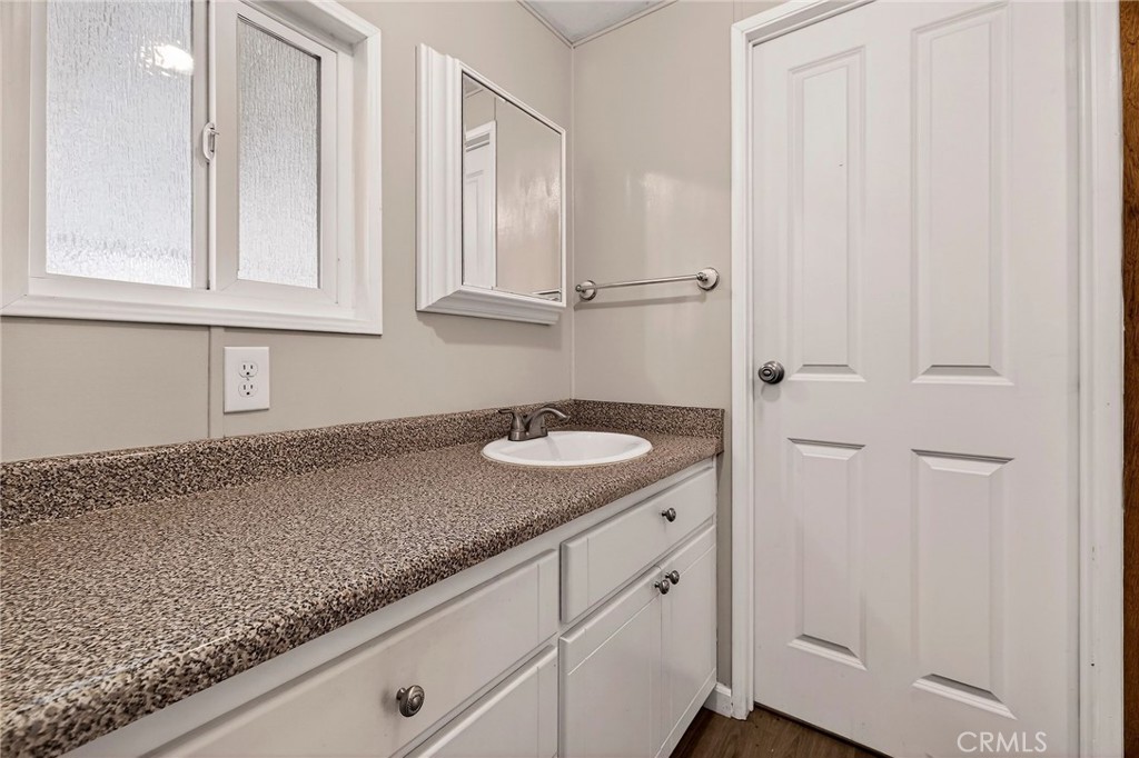 701 East Lassen Avenue, Unit 173 Chico, CA 95973 - Photo 26 of 49 a bathroom with a granite countertop sink and white cabinets