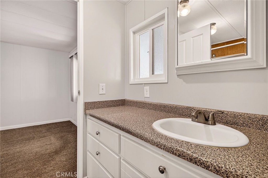 701 East Lassen Avenue, Unit 173 Chico, CA 95973 - Photo 27 of 49 a bathroom with a granite countertop sink and a mirror