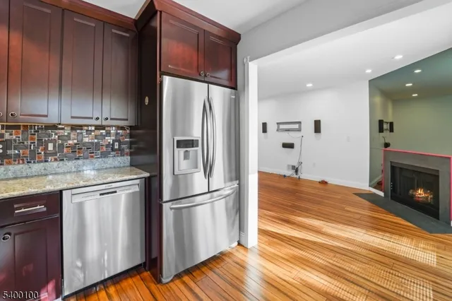 a kitchen with granite countertop wooden floors appliances and cabinets
