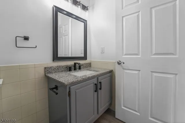 a bathroom with a granite countertop sink and a mirror