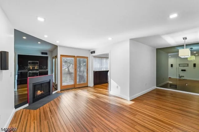 a view of a livingroom with wooden floor and kitchen space with a sink