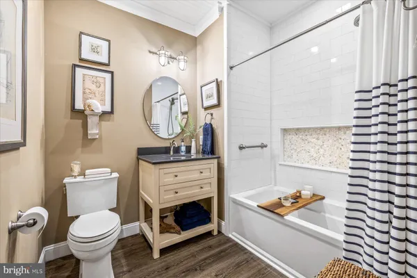 a bathroom with a toilet sink vanity granite and a mirror