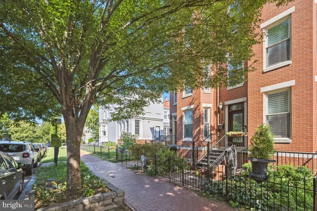a view of a brick house with a large windows and flower plants
