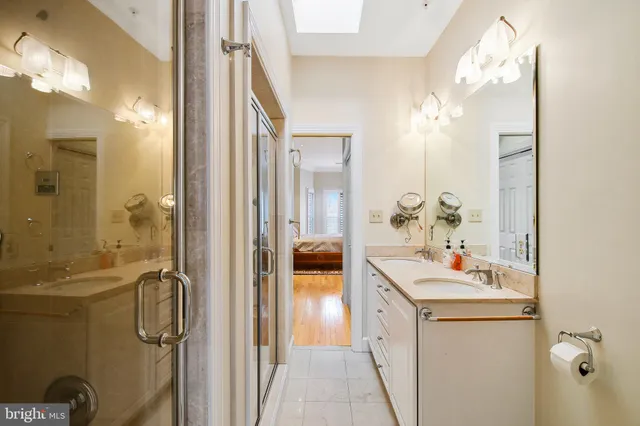 a view of an empty room with wooden floor and a bathroom