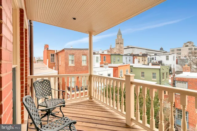 a kitchen with stainless steel appliances kitchen island granite countertop a dining table chairs and a refrigerator