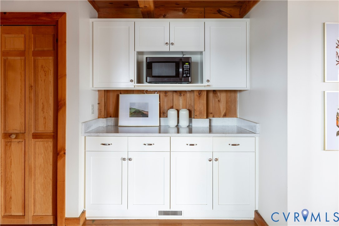 877 Twiggs Ferry Road Hartfield, VA 23071 - Photo 16 of 34 a kitchen with white cabinets and black appliances