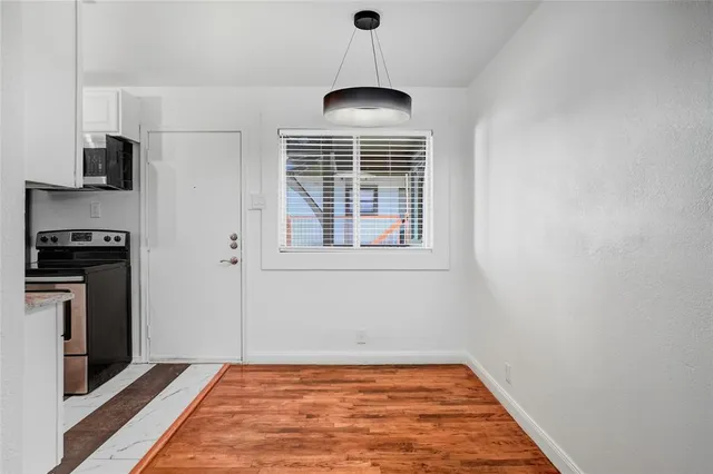 a view of empty room with a fireplace and wooden floor