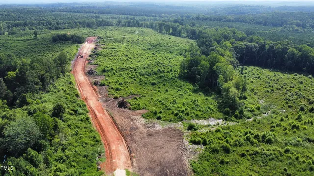an aerial view of residential house with outdoor space and trees all around