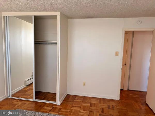 a view of a refrigerator in kitchen and an empty room