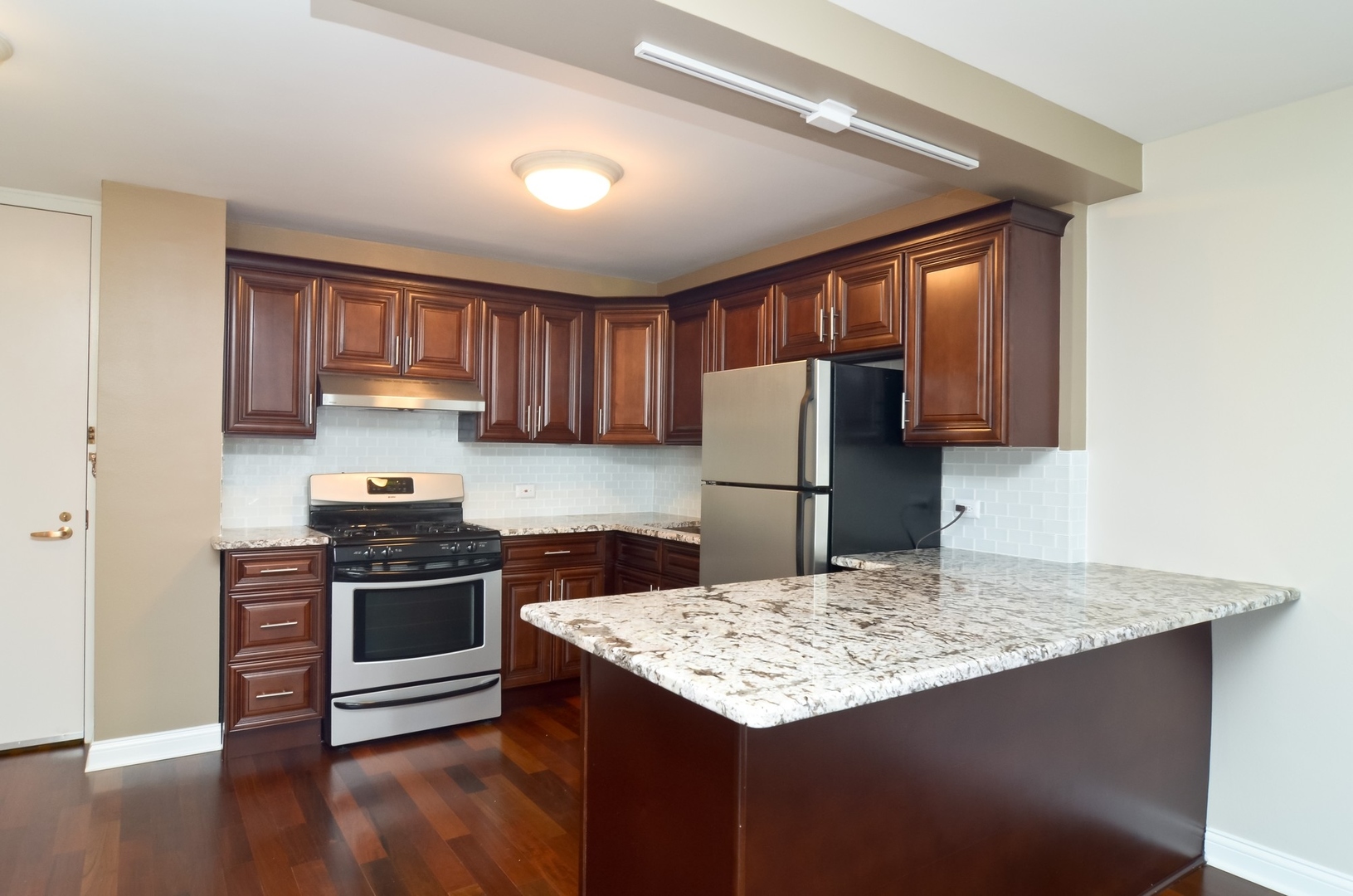 400 East Randolph Street, Unit 2302 Chicago, IL 60601 - Photo 2 of 22 a kitchen with refrigerator cabinets and wooden floor