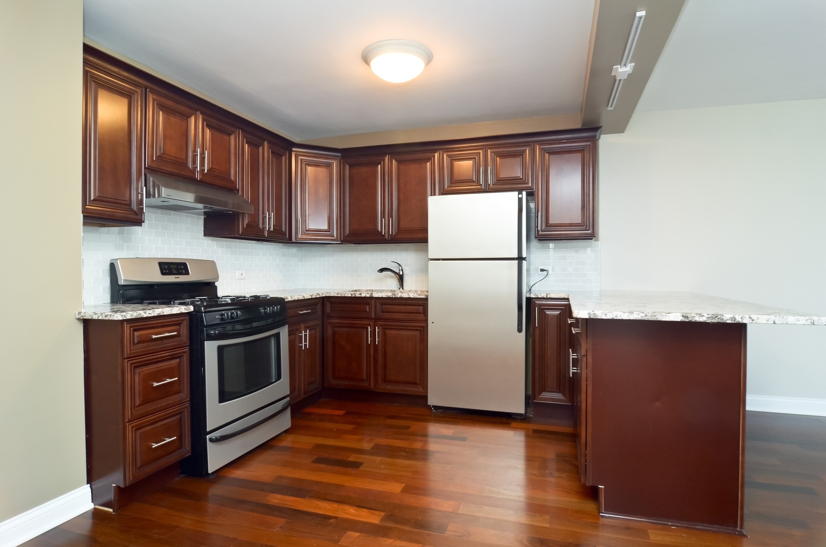 400 East Randolph Street, Unit 2302 Chicago, IL 60601 - Photo 3 of 22 a kitchen with wooden cabinets and stainless steel appliances