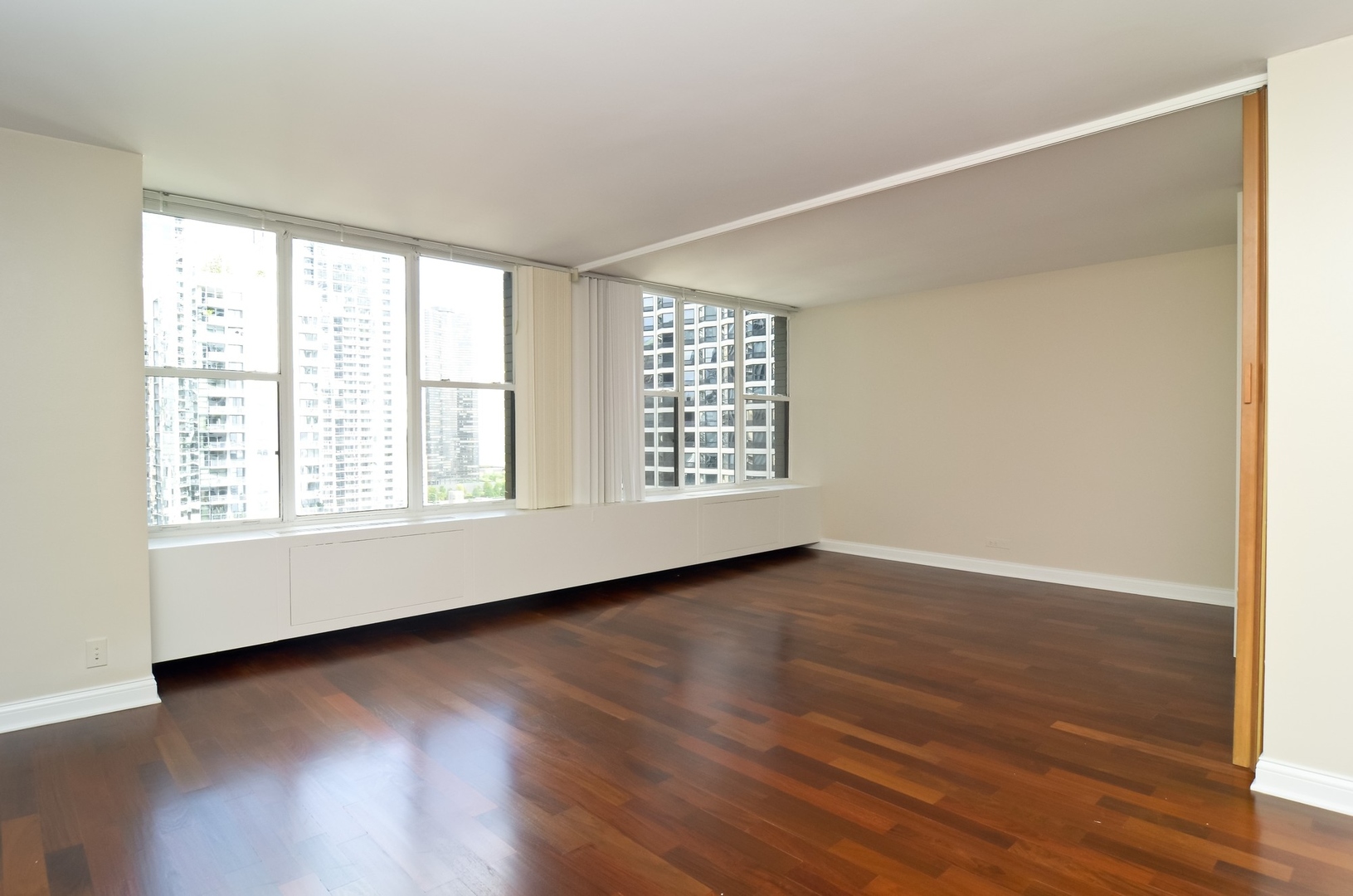 400 East Randolph Street, Unit 2302 Chicago, IL 60601 - Photo 4 of 22 an empty room with wooden floor and windows