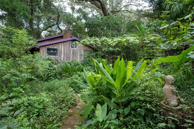 an aerial view of residential house with outdoor space and trees all around
