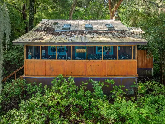 an aerial view of a wooden house with a yard