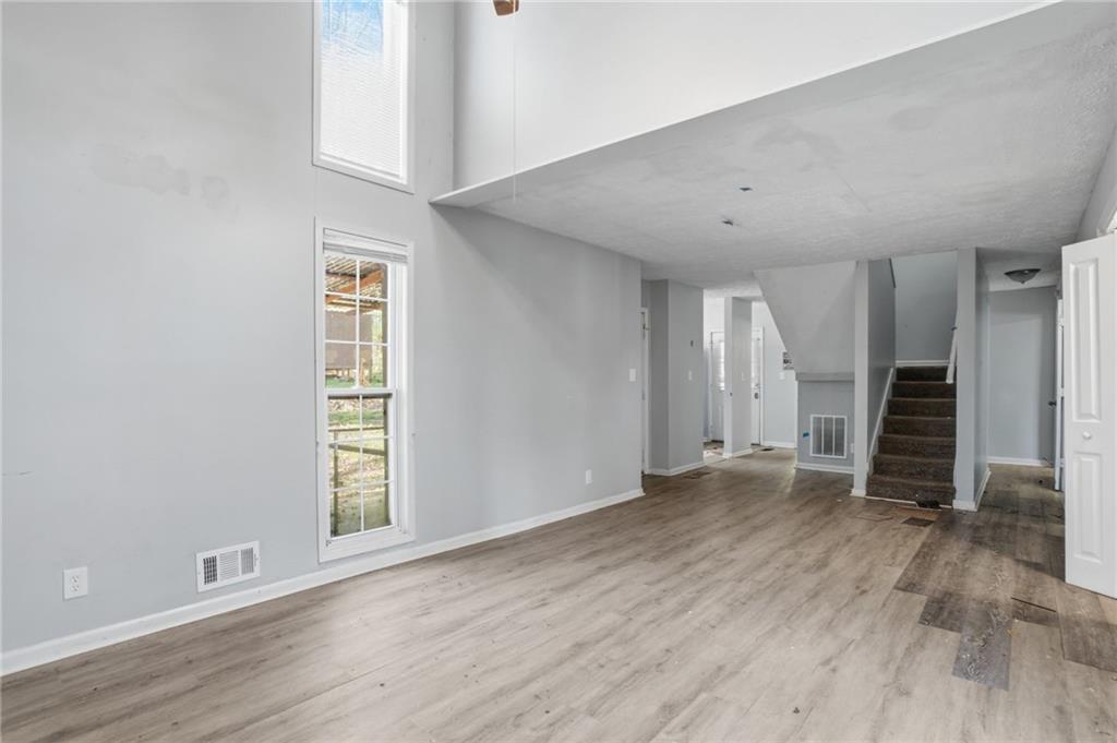 720 Twin Pines Road Covington, GA 30014 - Photo 15 of 40 an empty room with wooden floor and windows