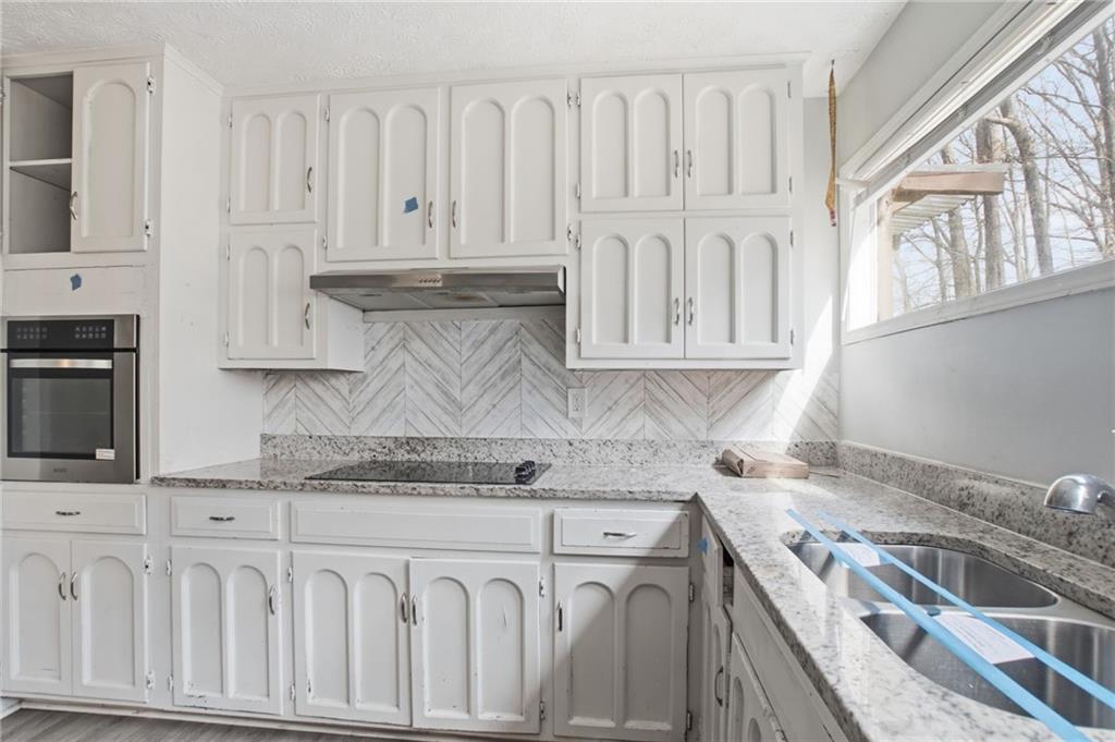 720 Twin Pines Road Covington, GA 30014 - Photo 16 of 40 a kitchen with granite countertop white cabinets and sink