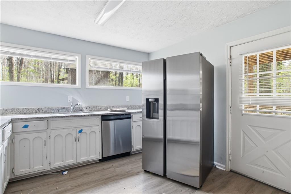 720 Twin Pines Road Covington, GA 30014 - Photo 18 of 40 a kitchen with stainless steel appliances granite countertop a refrigerator and a sink
