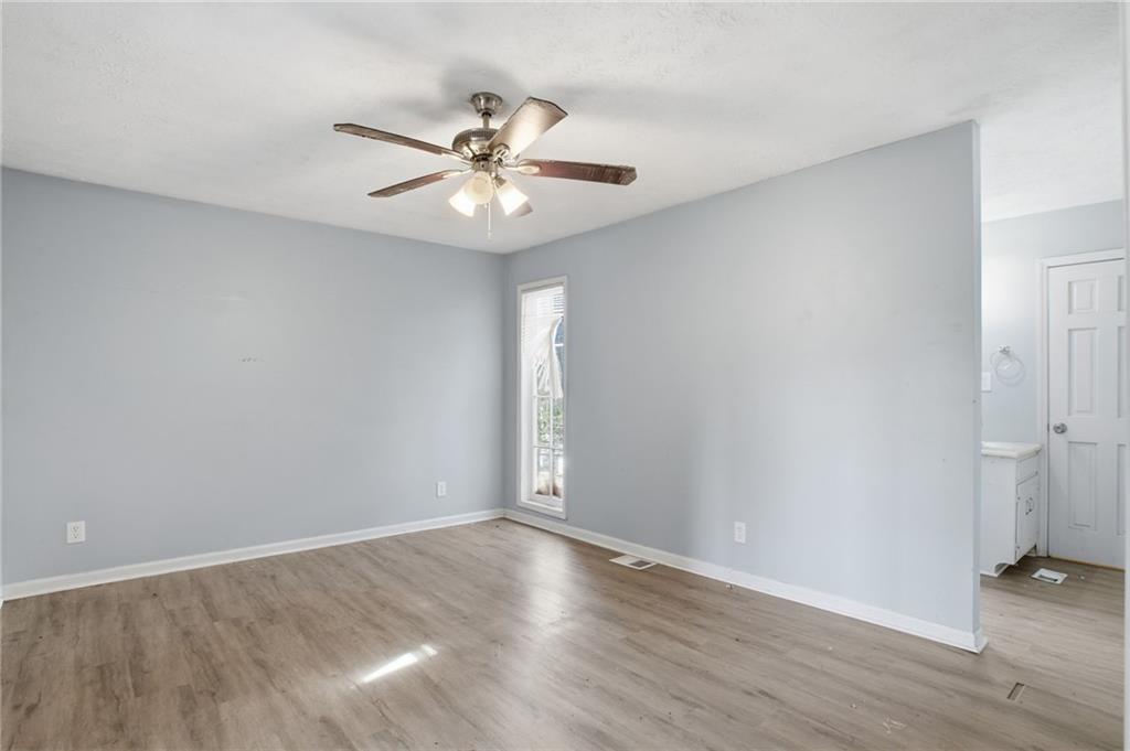 720 Twin Pines Road Covington, GA 30014 - Photo 20 of 40 an empty room with wooden floor and fan