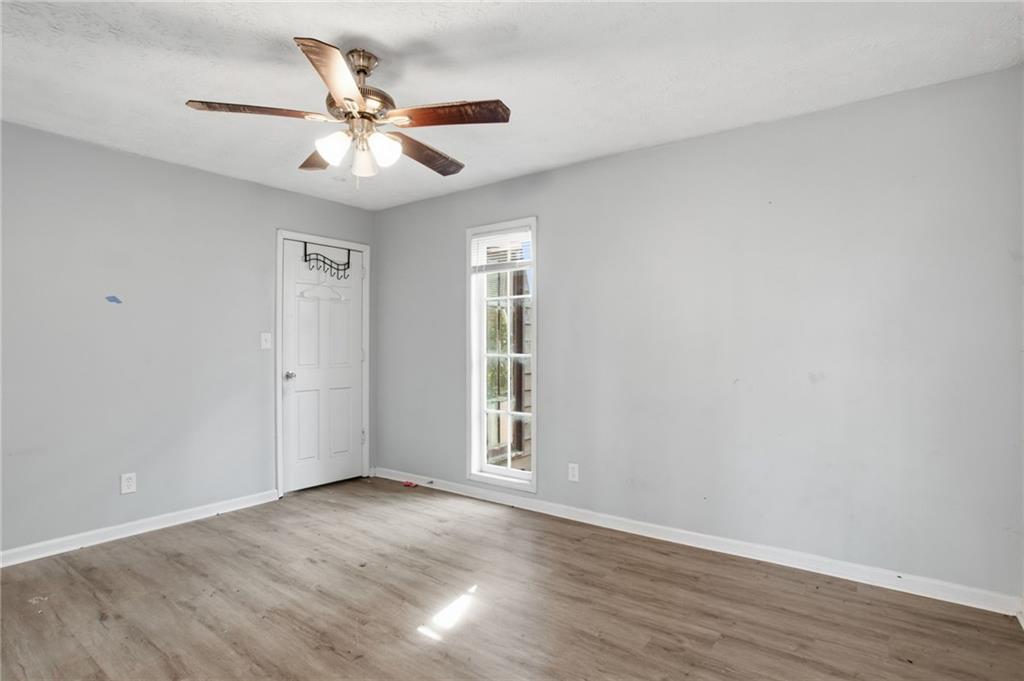 720 Twin Pines Road Covington, GA 30014 - Photo 21 of 40 a view of an empty room with wooden floor and a ceiling fan