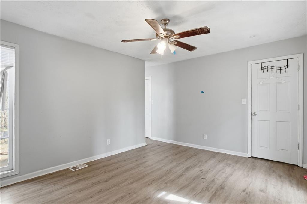 720 Twin Pines Road Covington, GA 30014 - Photo 22 of 40 an empty room with wooden floor fan and windows