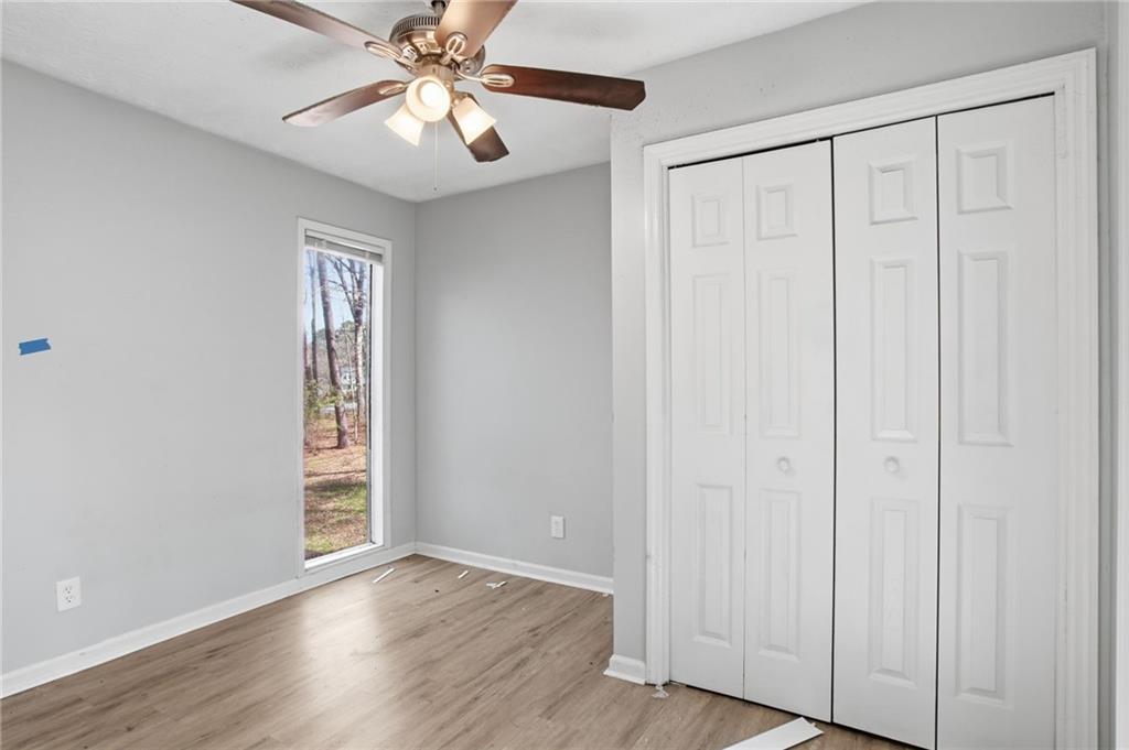 720 Twin Pines Road Covington, GA 30014 - Photo 26 of 40 an empty room with wooden floor closet fan and windows