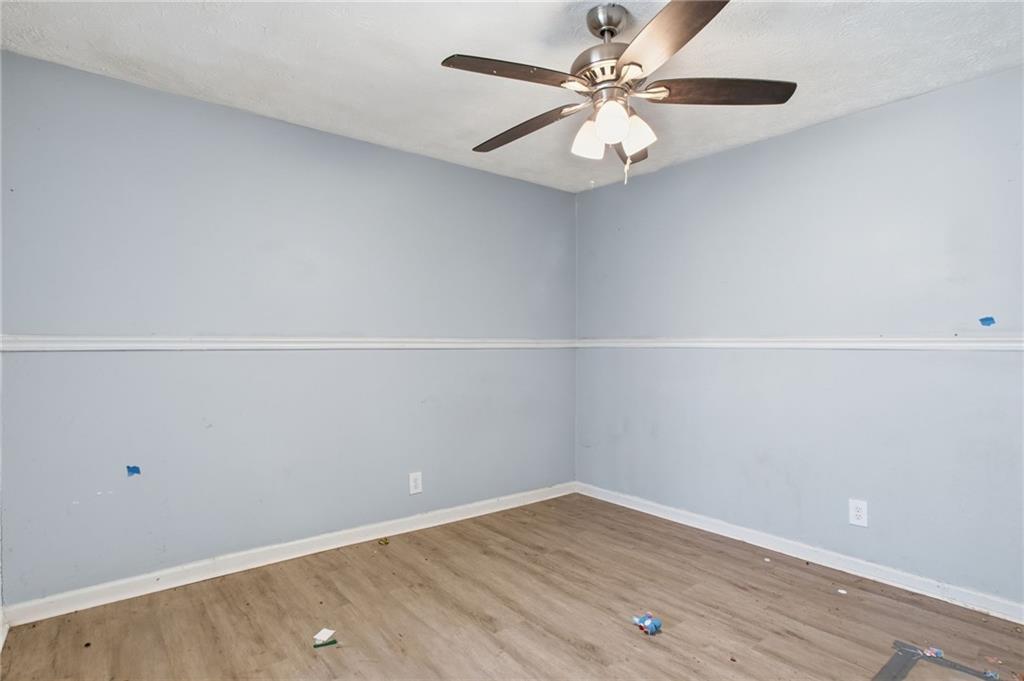 720 Twin Pines Road Covington, GA 30014 - Photo 27 of 40 an empty room with wooden floor and fan