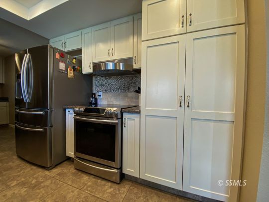 218 South Lilac Street Ridgecrest, CA 93555 - Photo 12 of 43 a kitchen with stainless steel appliances granite countertop a refrigerator and a stove