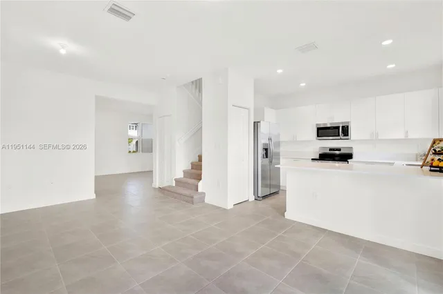 a view of a kitchen with refrigerator and a stove