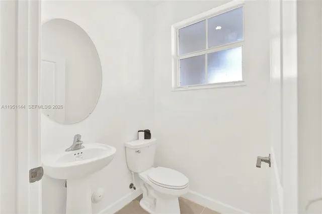 a white toilet sitting next to a bathroom sink