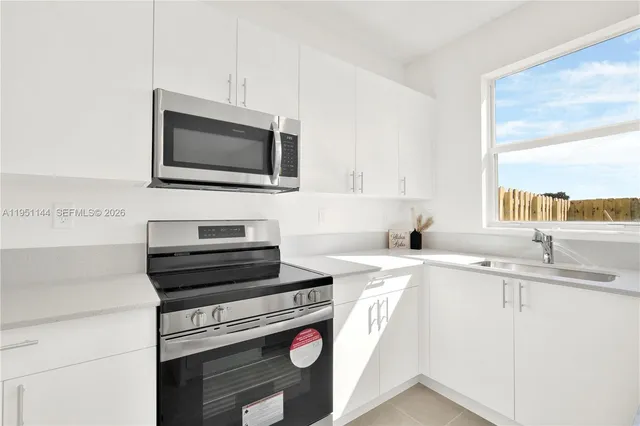 a kitchen with a sink stove and microwave
