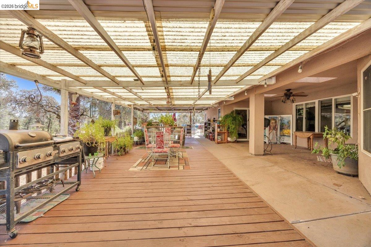 14450 Jacksonville Road Jamestown, CA 95327 - Photo 45 of 85 Expansive covered outdoor living area featuring a wood-plank deck, concrete patio, and a translucent panel roof