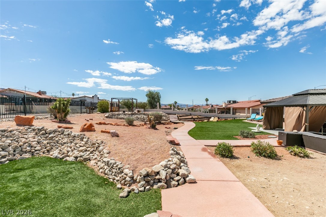 892 North Hollywood Boulevard Las Vegas, NV 89110 - Photo 57 of 81 This spacious yard offers a vibrant green lawn and a winding pathway, perfect for outdoor relaxation.