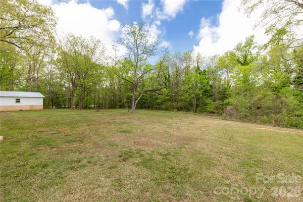 a view of a field with trees in the background
